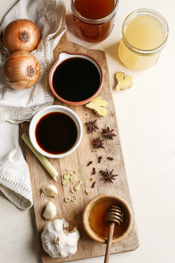 ingredients needed to make broth for vietnamese soup on a wooden cutting board