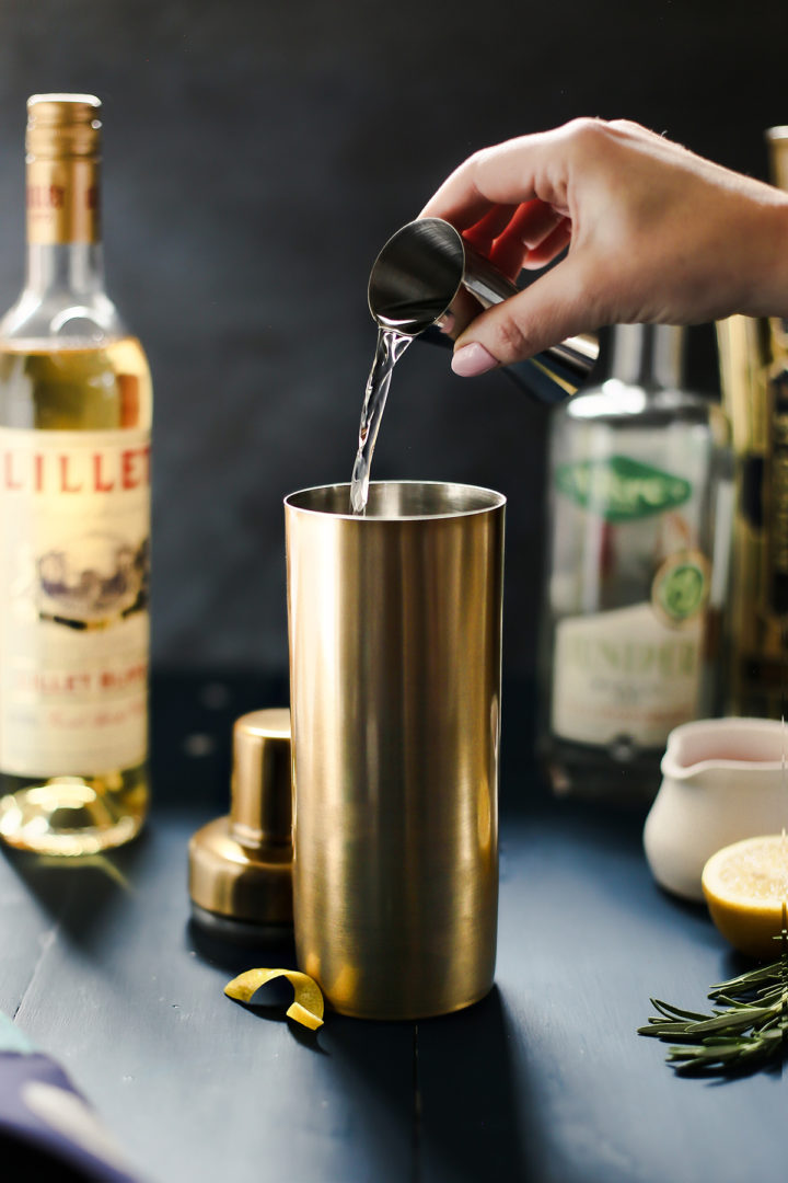 woman pouring gin in a cocktail shaker