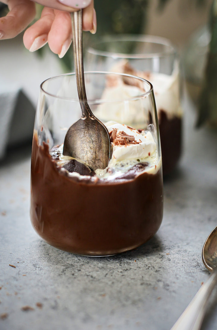 woman eating a glass of homemade chocolate pudding