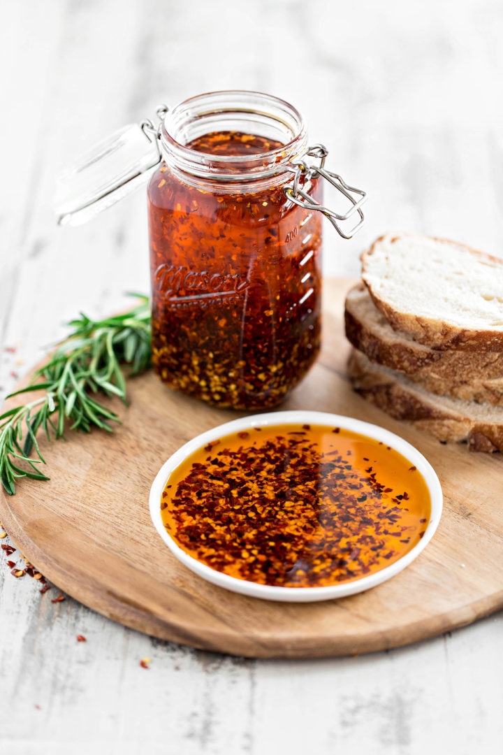 chili garlic oil on a white plate with sliced bread