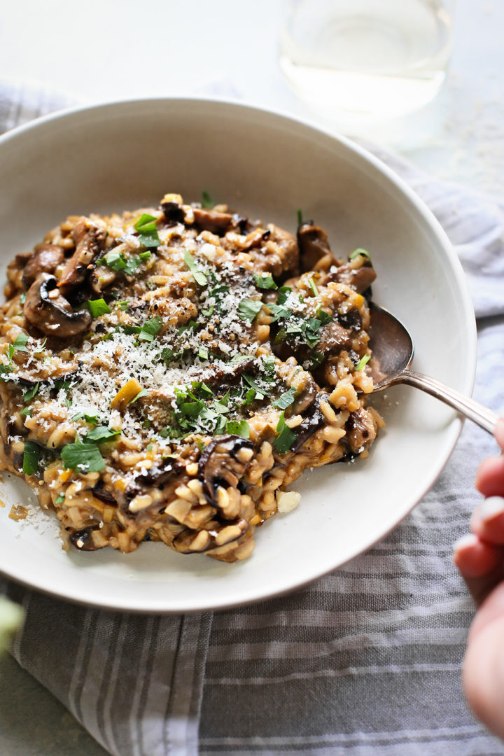woman eating a bowl of the best mushroom risotto