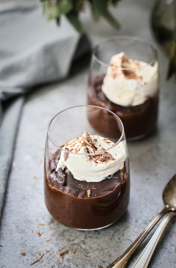 dark chocolate pudding in glasses with whipped cream garnish