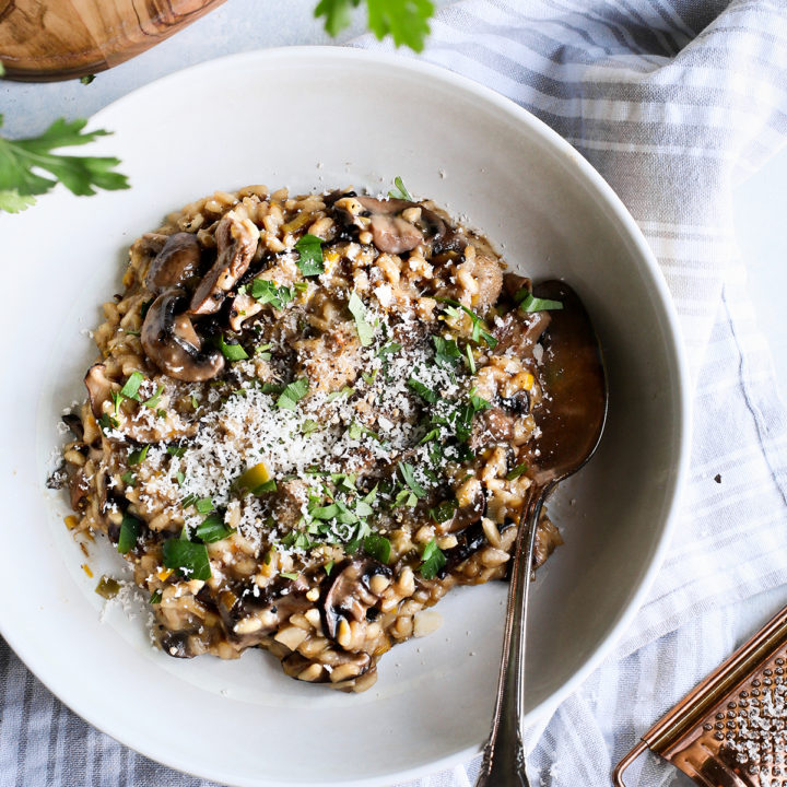 creamy mushroom risotto served in a white bowl