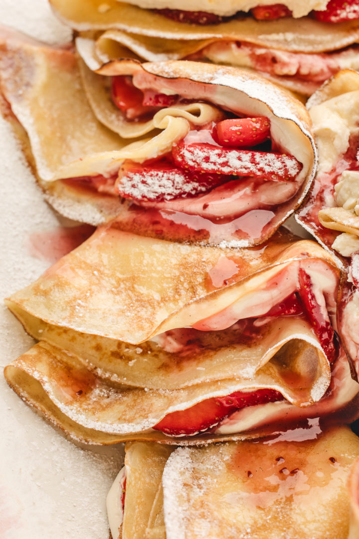 a platter with homemade crepes with strawberry filling 
