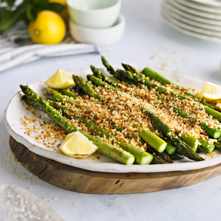 a white platter of traeger grilled asparagus