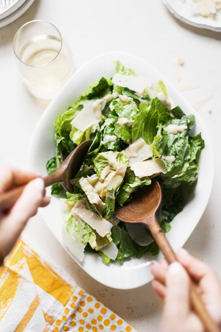 woman mixing salad dressing with homemade caesar salad ingredients
