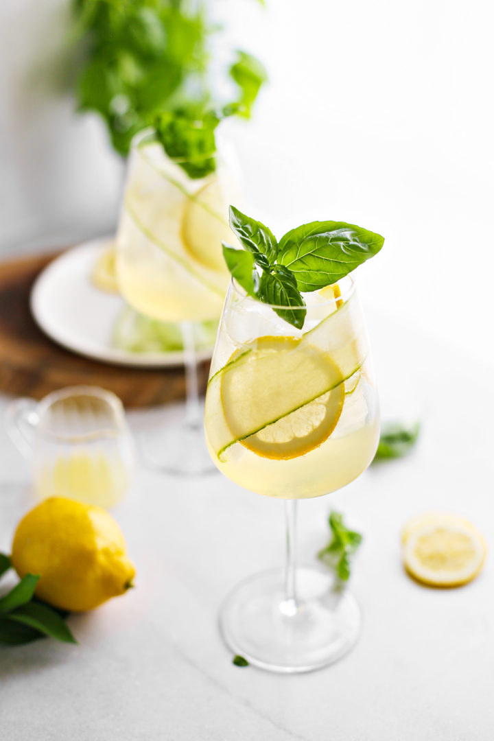 two glasses of spritz with St. Germain
garnished with fresh lemon, basil, and cucumber