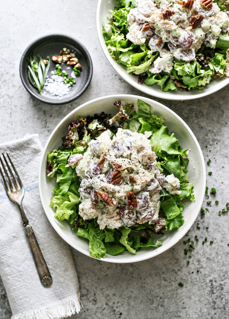 two white bowls with spring greens and tarragon chicken salad