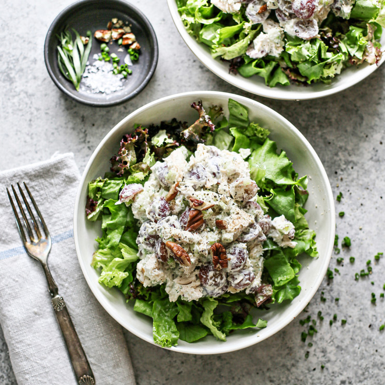 two white bowls with spring greens and tarragon chicken salad