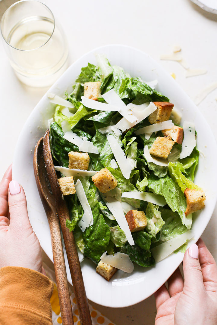 sourdough croutons on top of salad in a white bowl