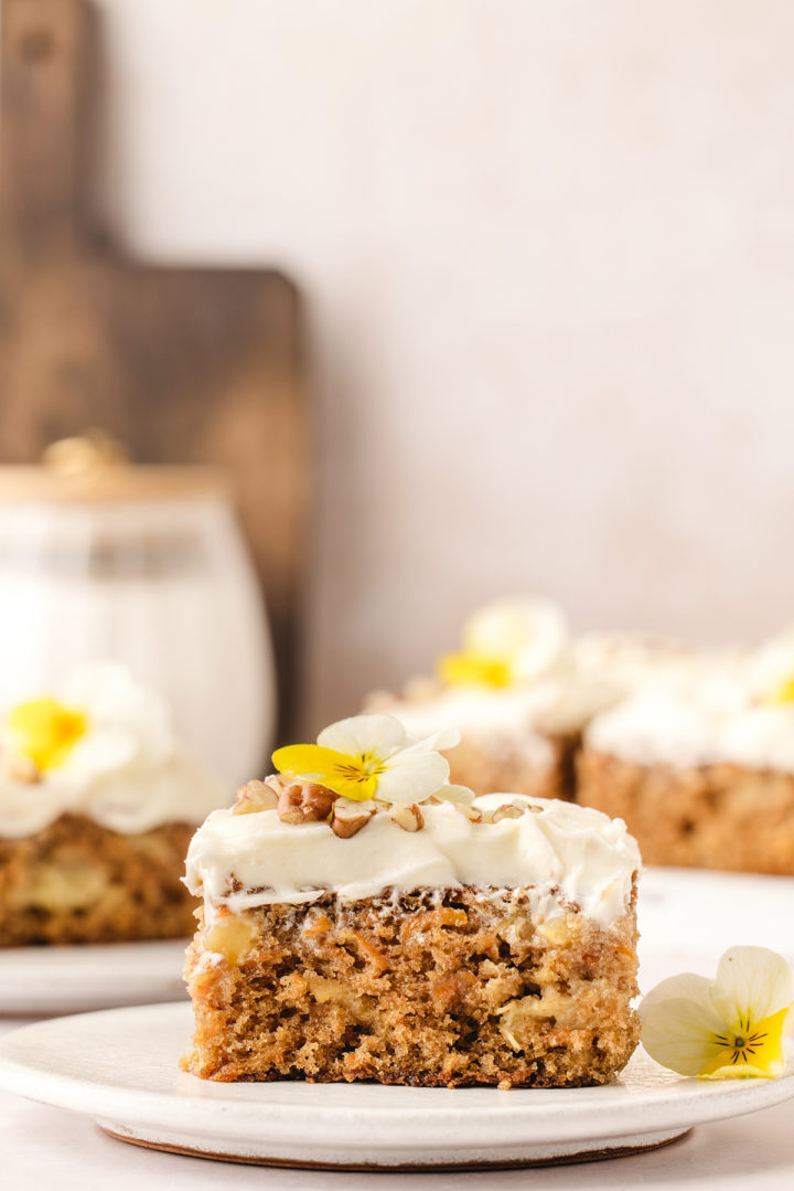 a white plate with a slice of pineapple carrot cake