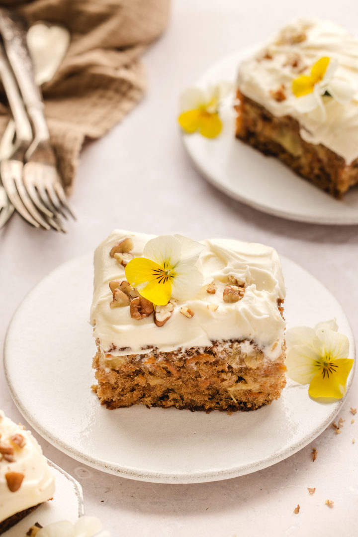 two white plates with slices of carrot cake with pineapple 
