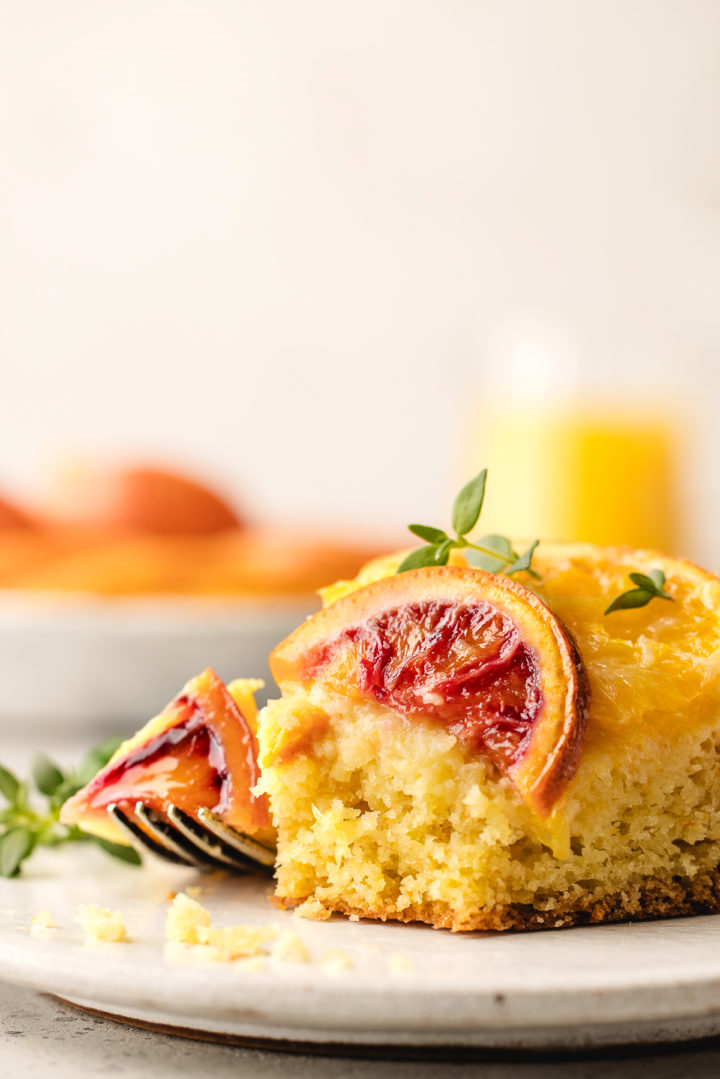 upside down orange cake with a bite taken out of it on a plate with a fork