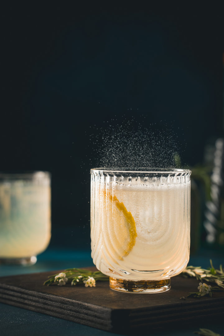 gin fizz cocktail in a glass on a wooden cutting board
