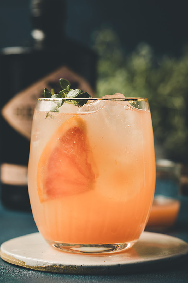 gin and grapefruit tonic in a glass with a gold rim