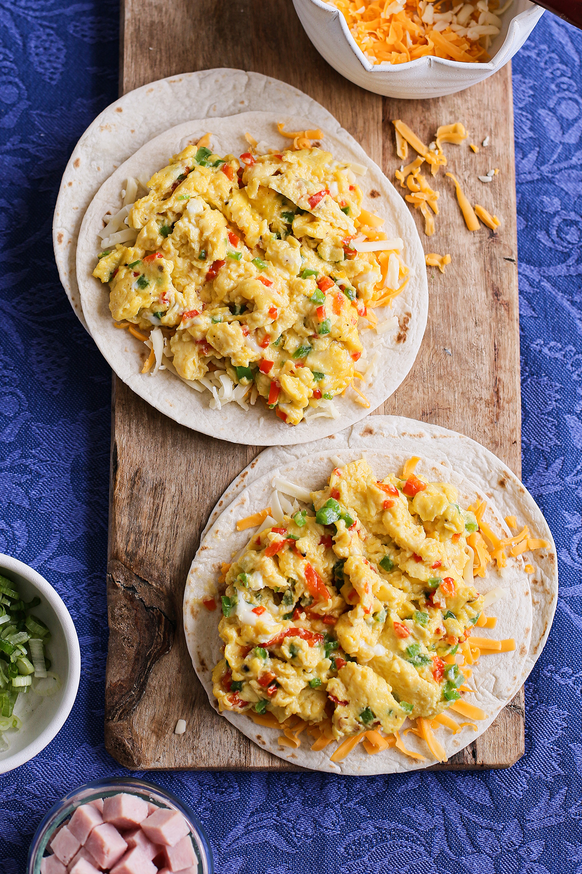 tortillas with cheese and scrambled eggs assembling a recipe for breakfast quesadillas