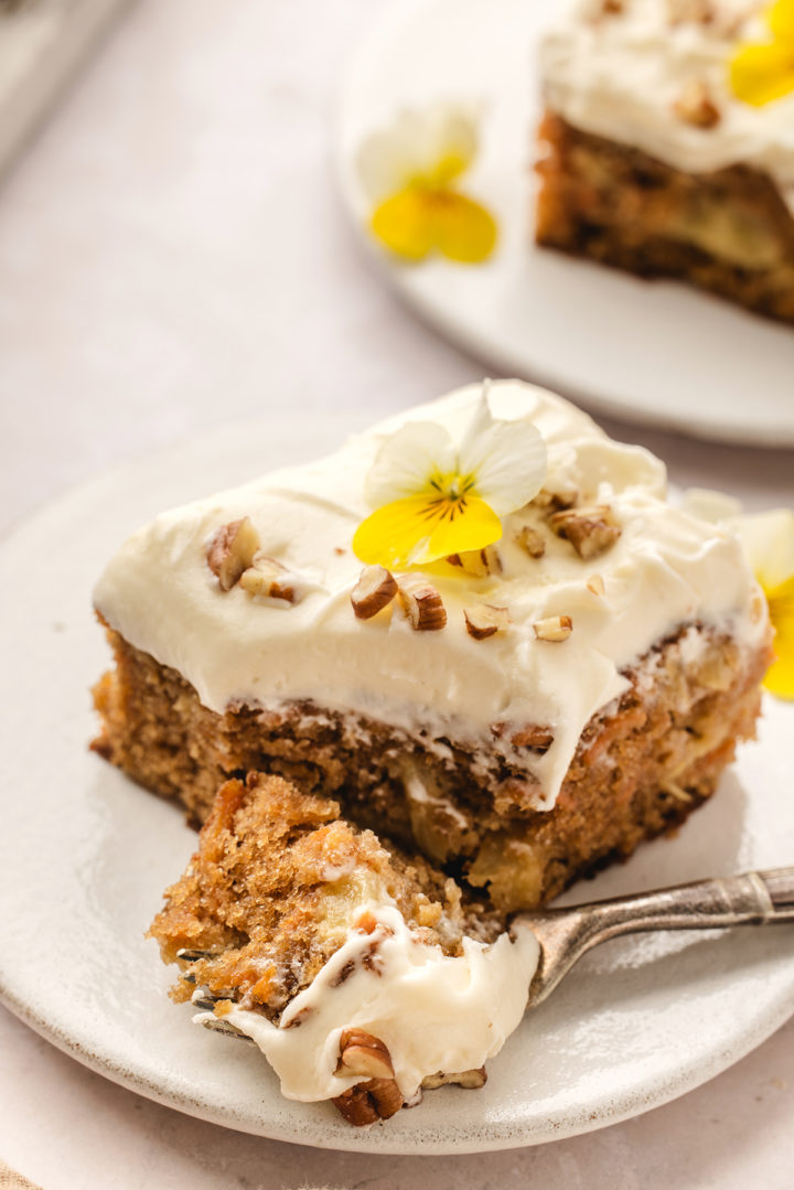 a carrot cake with pineapple with a bite taken out of it and a fork