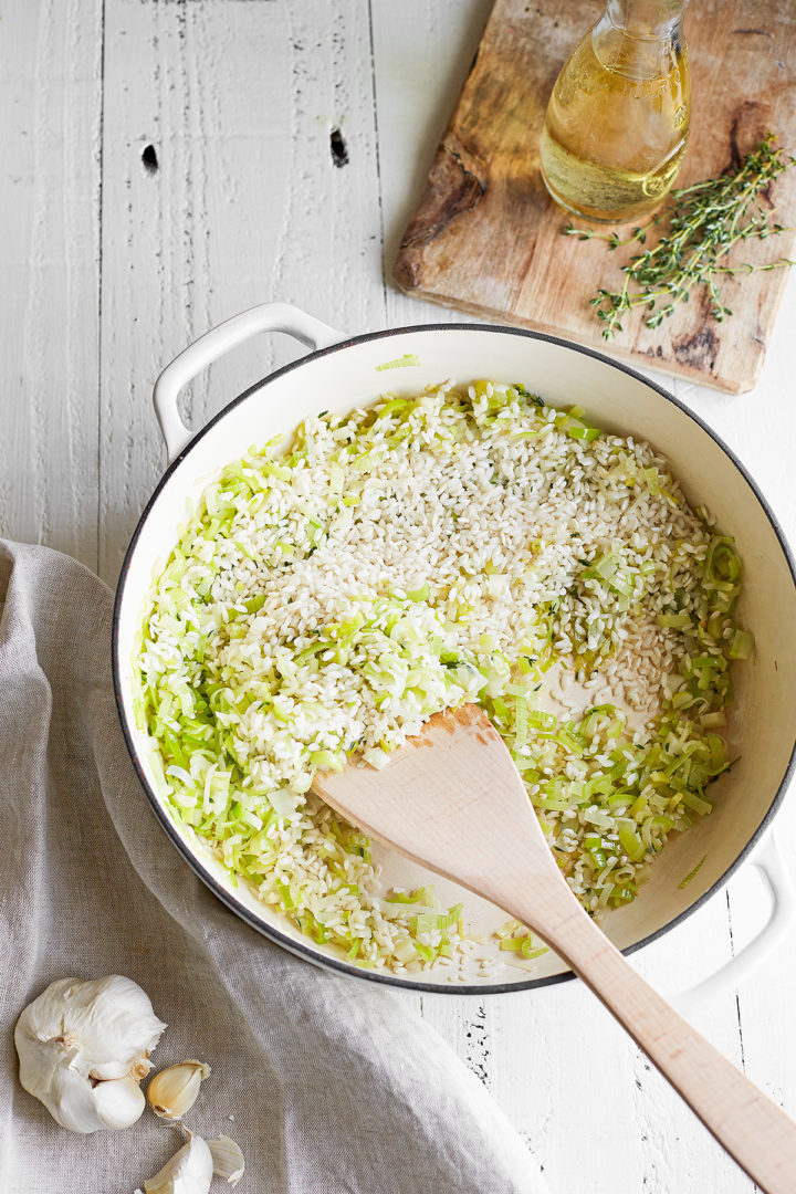 arborio rice being cooked with leeks for pea risotto