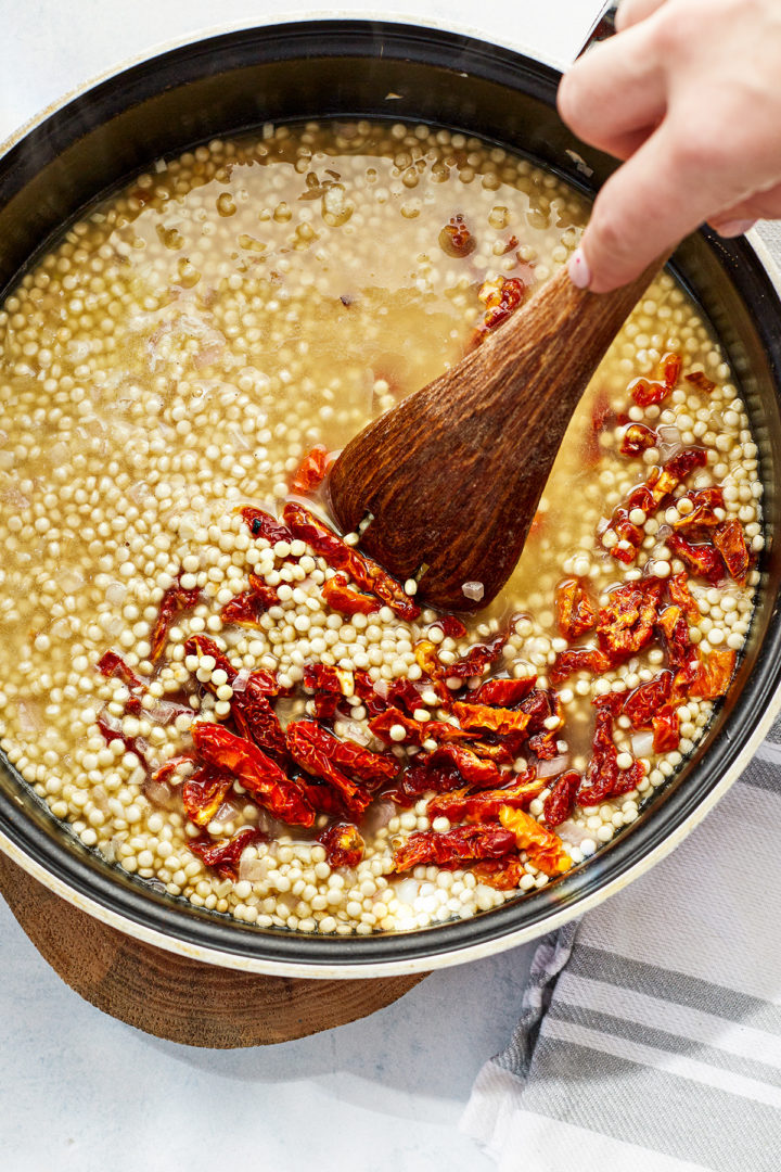 how to make pearl couscous salad: step 3 - add the broth and sundried tomatoes