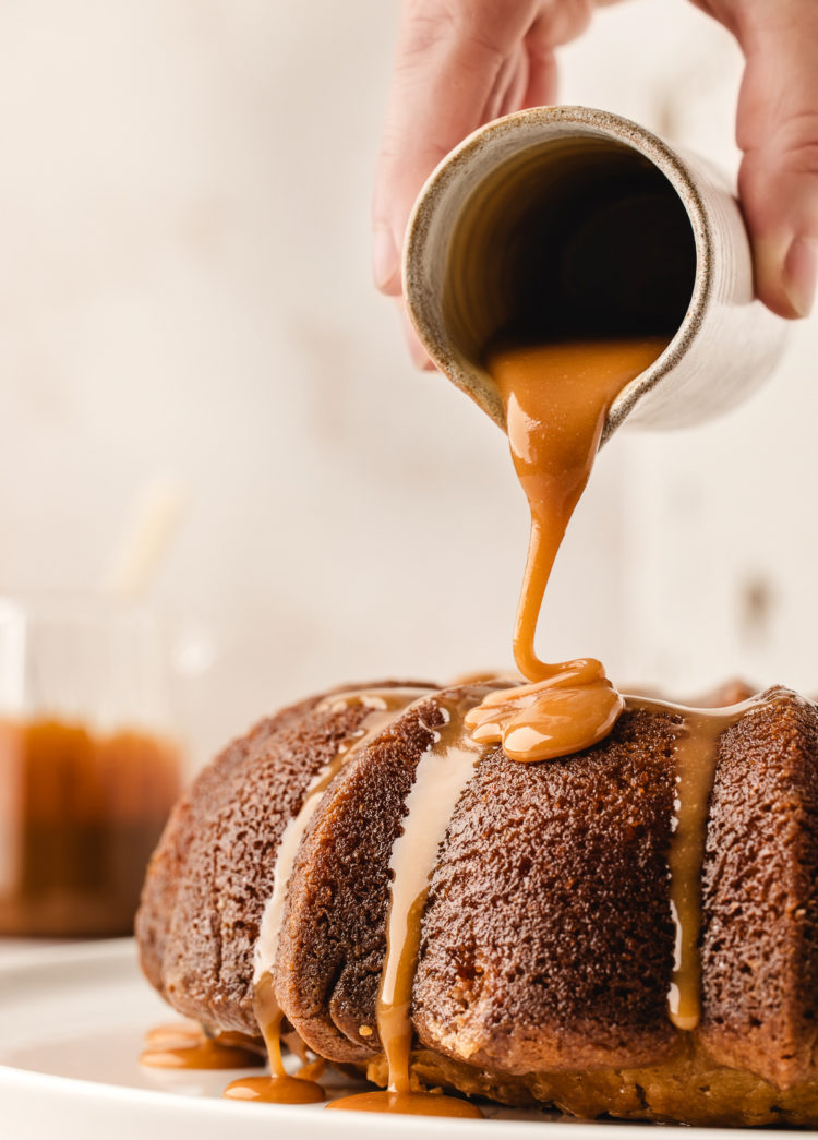 pouring salted caramel sauce on top of a kentucky butter cake