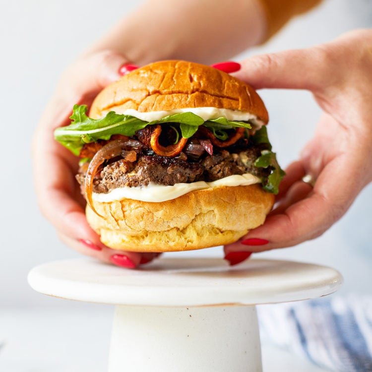 woman holding a blue cheese burger