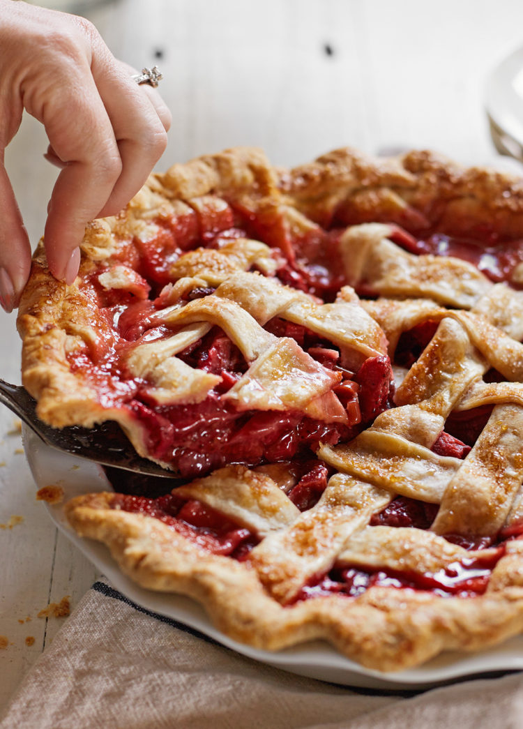 woman serving a strawberry rhubarb pie