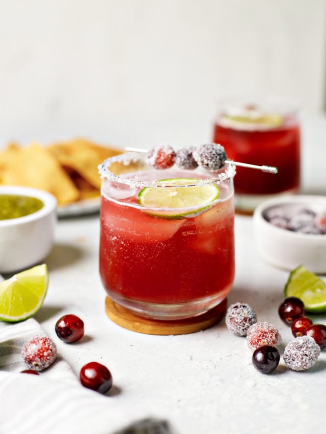 glasses of cranberry margaritas with lime and cranberry garnish