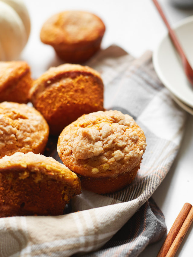 a batch of high protein pumpkin muffins on a plaid dish towel