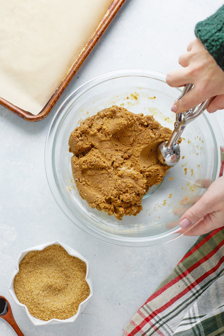 Woman scooping out gingersnap cookie dough