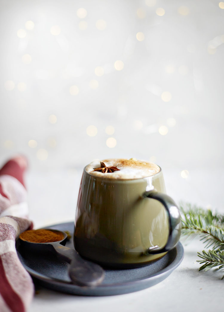 mug of gingerbread chai latte surrounded by white christmas lights