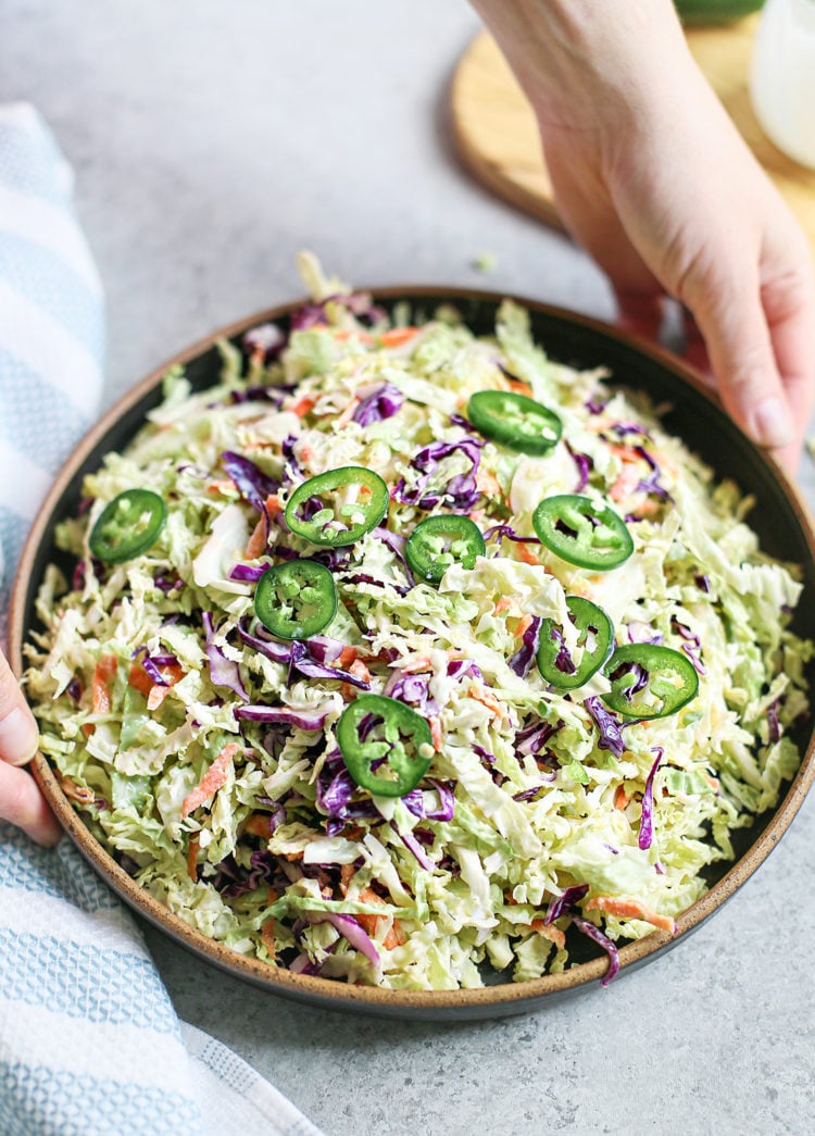 woman holding a bowl of coleslaw