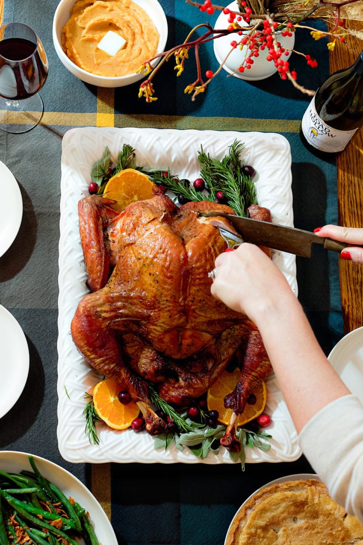 Carving a spatchcock smoked turkey on a serving platter.