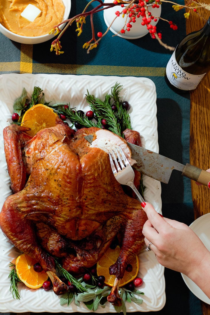 Carving a spatchcock smoked turkey on a serving platter.