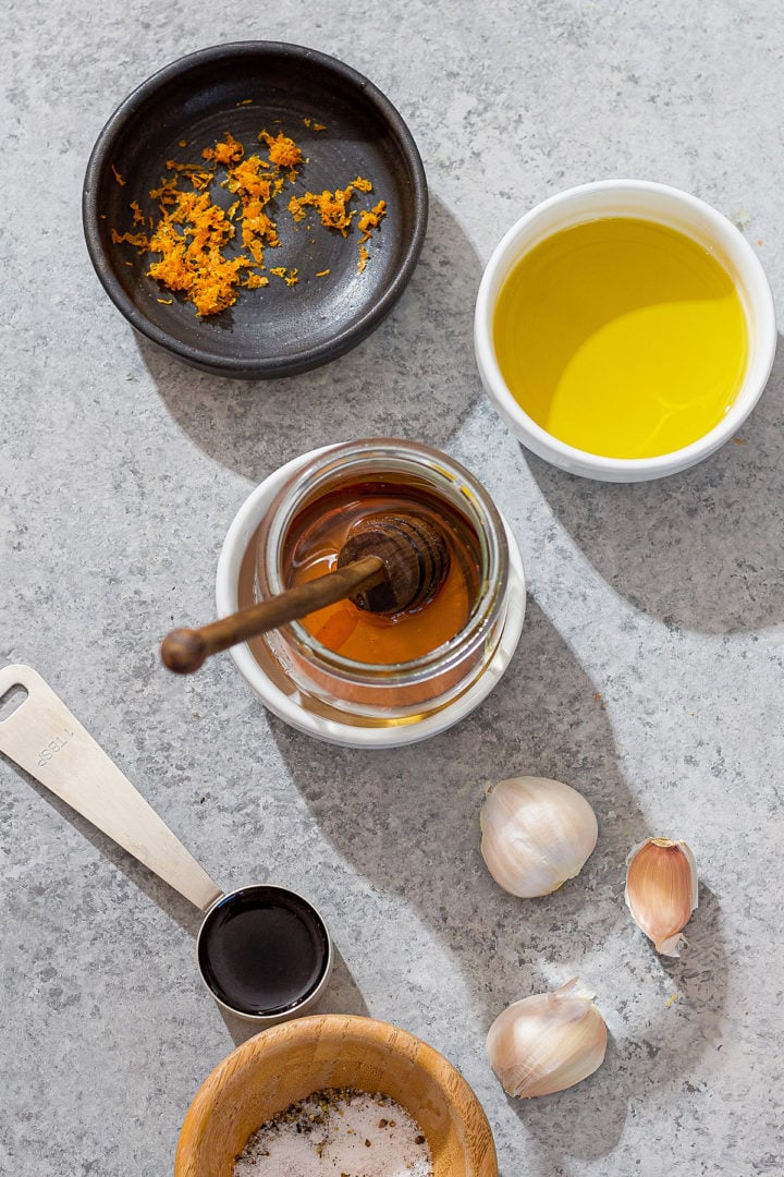 Ingredients for honey roasted parsnips and carrots: olive oil, honey, balsamic vinegar, garlic, orange zest, and salt.