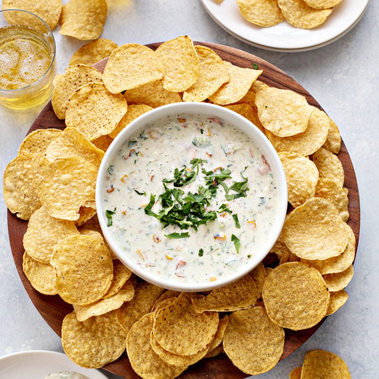 overhead photo of a bowl of queso blanco surrouonded by tortilla chips